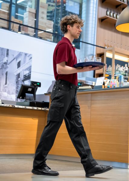 Un employé de service dans la restauration porte un pantalon de service pour hommes.